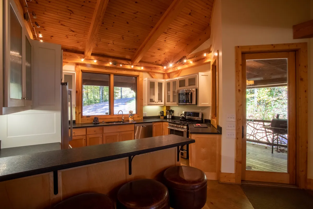 A spacious kitchen with a large island, high-end cabinetry, and a prominent window that fills the space with natural light. The arrangement encourages group cooking, family gatherings, or preparing meals before or after a day out exploring.